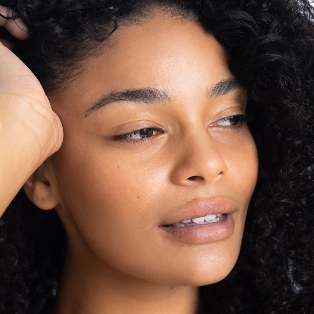 Close-up of a woman with curly hair, focusing on her face.