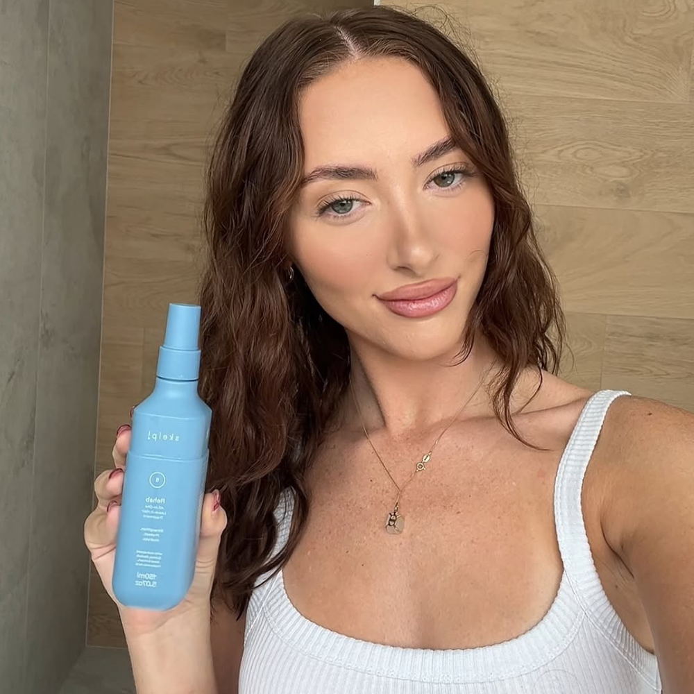 real customer holding skelp rehab all in on haircare treatment showing real results of beautiful hydrated hair