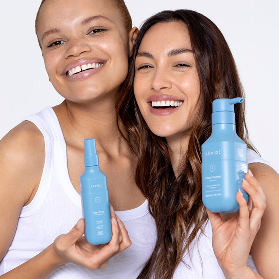 Two models holding skelp! pre-cleanser and shampoo