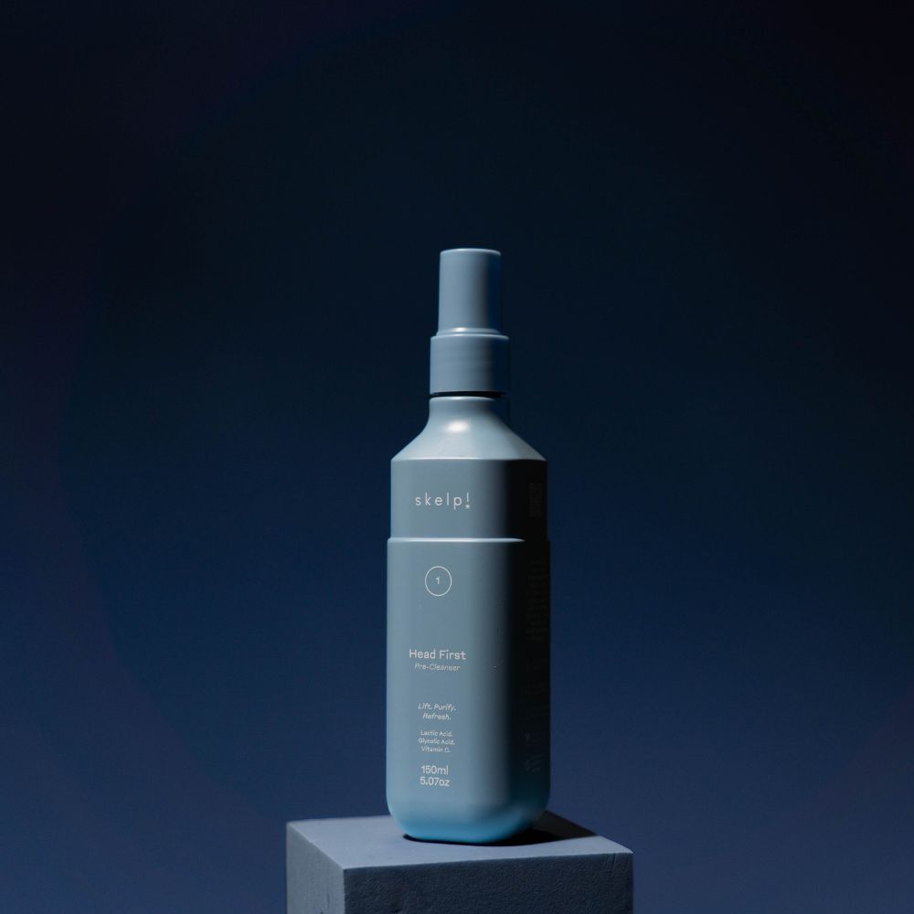 skelp! pre cleanser for hair, hero shot sitting on blue box for double cleanse hair product
