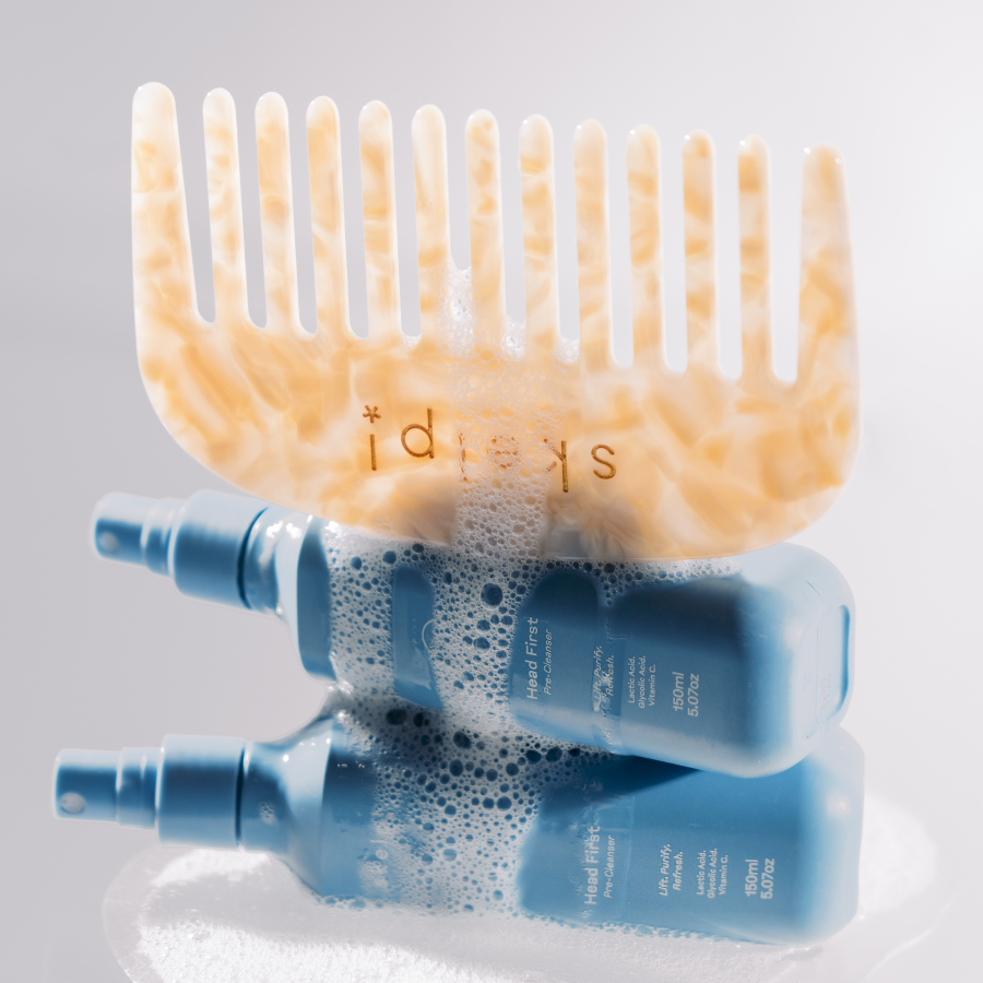 skelp! premium wide tooth comb sitting on scalp haircare bottles with water dripping over