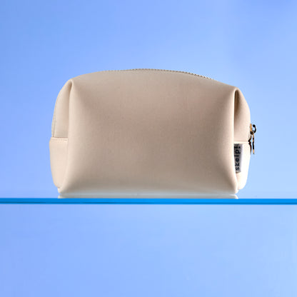 high quality cream makeup bag sitting on bathroom shelf. Shot for summer travel and Christmas