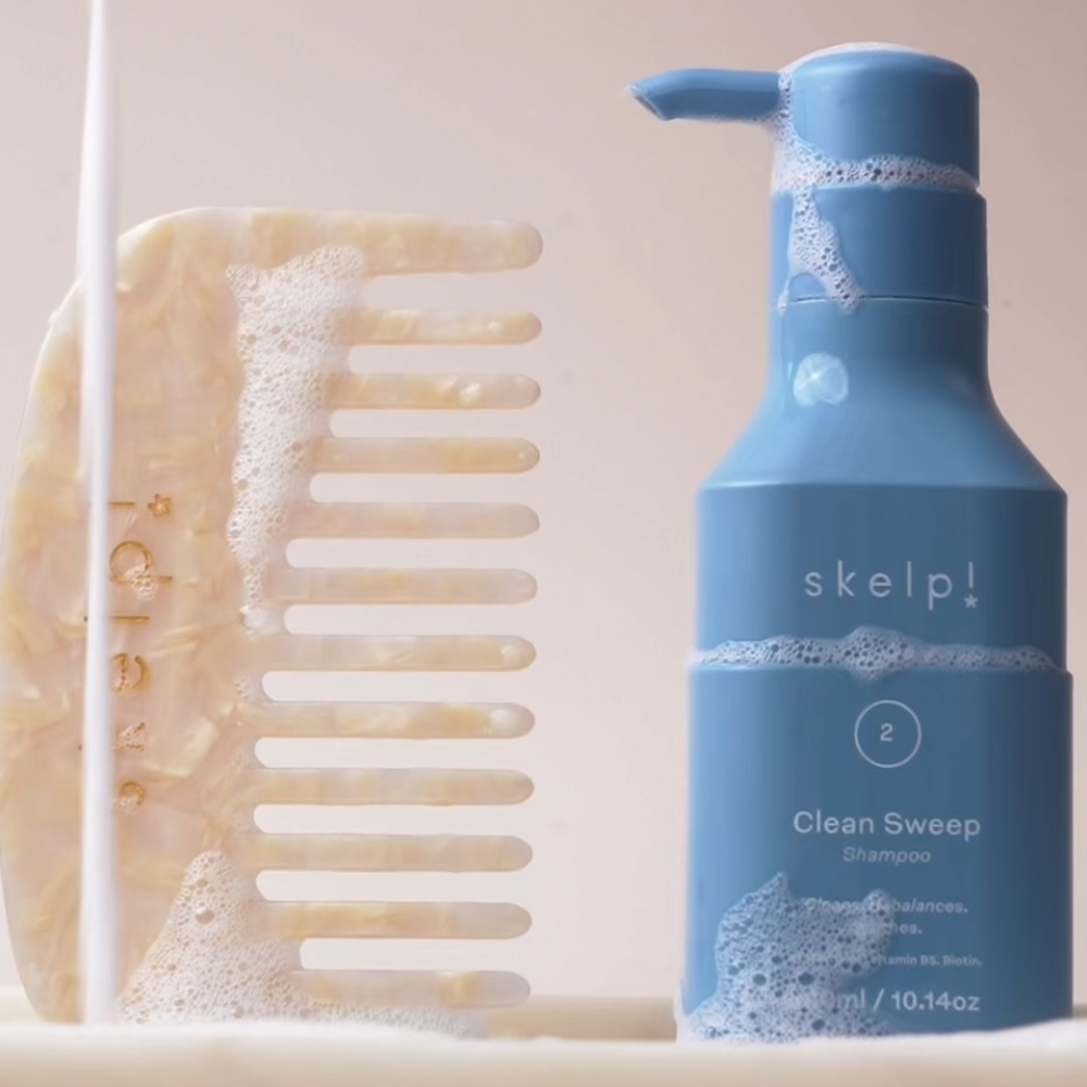 bubble and water dripping over skelp shampoo bottle and wide tooth comb 
